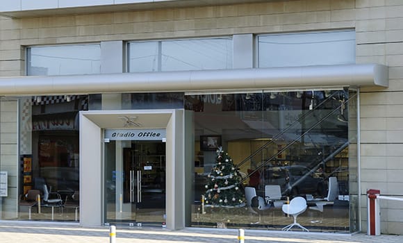 Nicosia Showroom virtual showroom, glass storefront with Studio Office sign and Christmas tree inside.