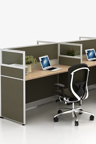 Office space featuring low partitioning screens, laptops, and ergonomic chair.