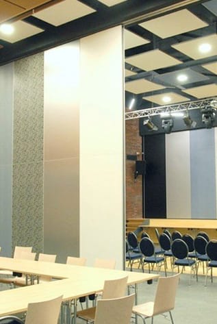 Movable walls in a conference room with a stage and tables.