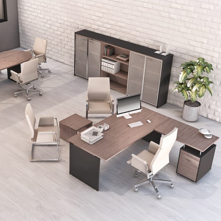 Contemporary office space showcasing Cosmos Managerial light wood furniture, complemented by multiple beige chairs. The room features a spacious desk with a computer, ample storage cabinets, a round meeting table, and a potted plant atop light flooring. Studio Office Cyprus