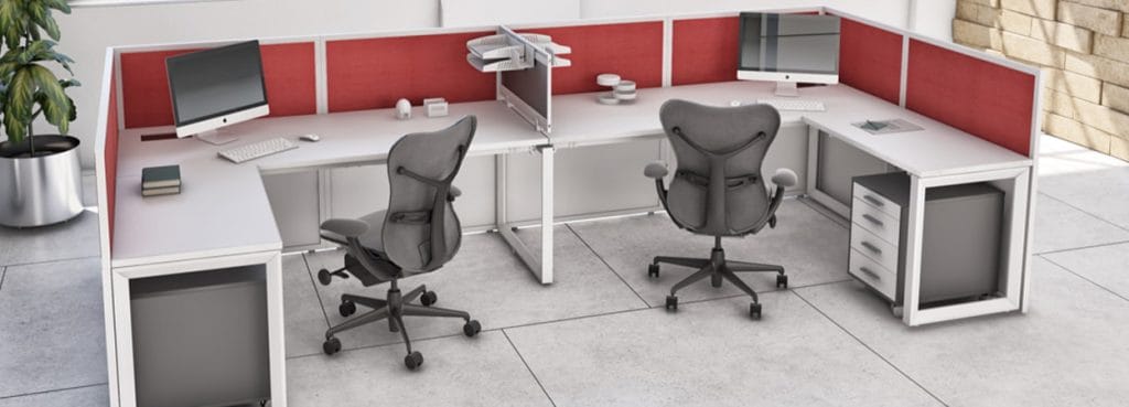 Modern white Cubiko Operative desks with red privacy panels, gray chairs, and computer monitors in a bright office space.