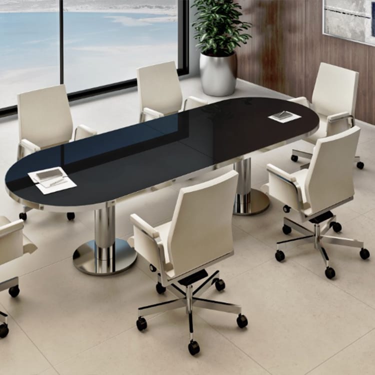 The Manager EVO Conference room features a sleek black oval table surrounded by six white wheeled chairs, complemented by a potted plant in the corner and expansive windows offering scenic outdoor views. Studio Office Cyprus
