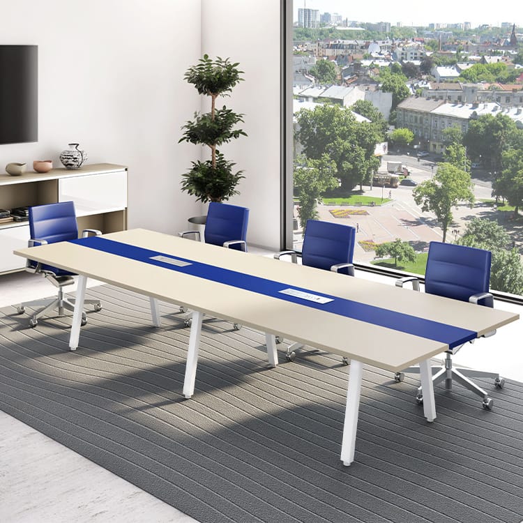 The Lamda Conference Room showcases a spacious long table surrounded by blue chairs, bathed in natural light from a large window that offers a sweeping city view. A potted plant and tasteful decorative accents on the background cabinet add elegance to the modern setting. Studio Office Cyprus