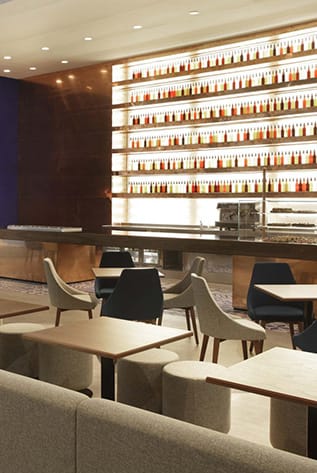 Stylish bar interior with tables, chairs, and a wall of liquor bottles. Modern Bars for hospitality.