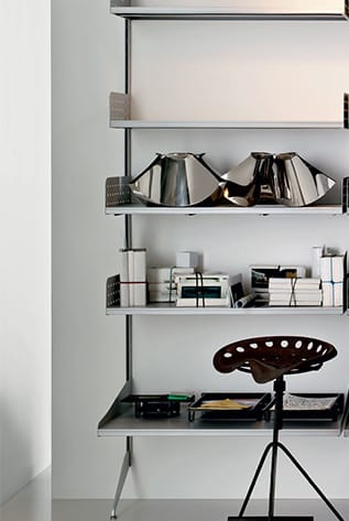 Modern modular systems with metal shelves, desk, and tractor seat stool.