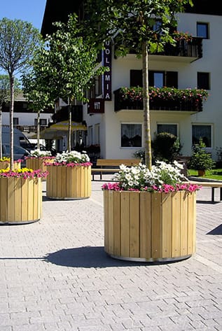 Outdoor wooden Planters with colorful flowers, ideal for gardens or patios.