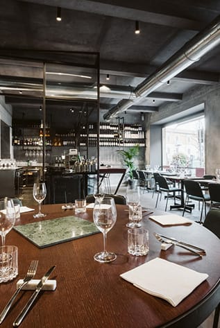 Upscale Restaurants: Dark wood tables, glassware, and sleek decor create an inviting dining atmosphere.