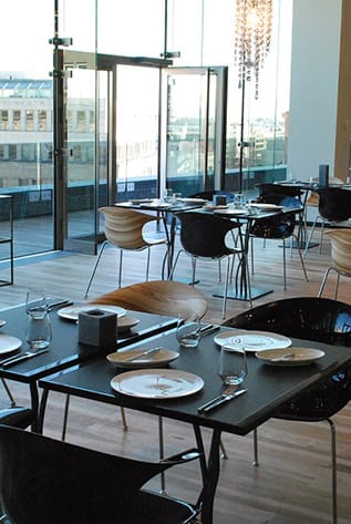 Modern Restaurants: Black tables set with plates, glasses, cutlery. Stylish chairs.