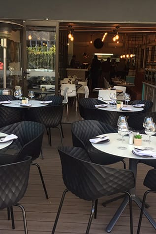 Stylish Restaurants: Black quilted chairs and white tables create an inviting dining space.