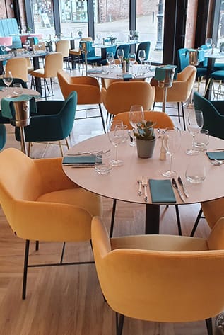 Stylish Restaurants: Mustard and teal velvet chairs around a set table. Modern furniture for hospitality.