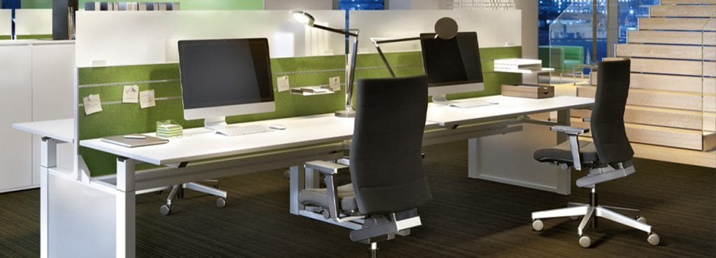 Modern office with ergonomic CHAMP chair in black fabric and white desk.