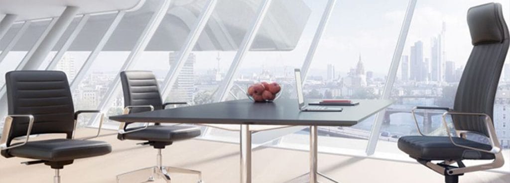 Modern office with black leather VINTAGEis5 chairs and table, offering ergonomic seating and stylish design.
