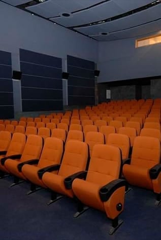 Comfortable orange Cinema seating with cup holders and superior lumbar support.