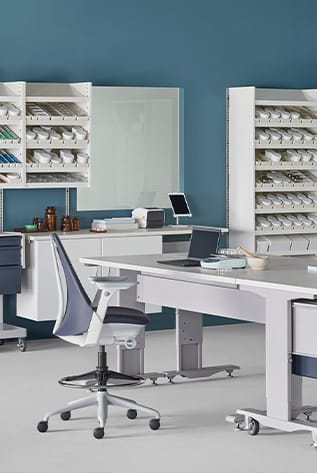 Modern healthcare furniture: ergonomic chair, adjustable tables, and storage solutions in a bright, organized facility.