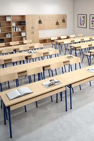 Classroom furniture for Higher Education. Light wood desks with blue metal legs, and matching storage cabinets.
