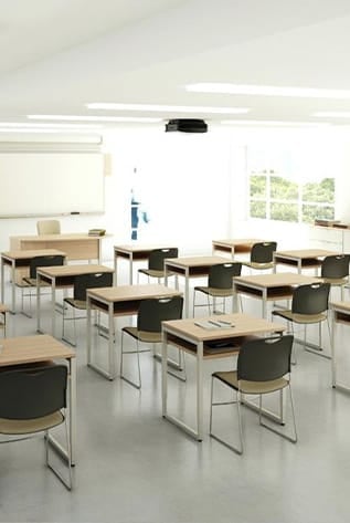 Modern classroom furniture for Higher Education. Light wood desks with black chairs in a bright, clean setting.