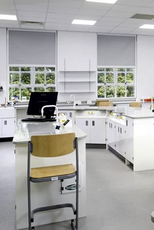 Bright, functional laboratory. White Laboratory Furniture with chair, computer, and natural light.
