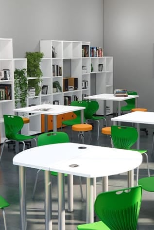 Bright library furniture: white tables, green chairs, and modular shelving.