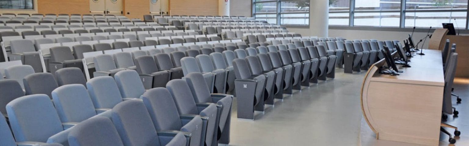 Indoor Amphitheater seating in gray, with a light wood podium.