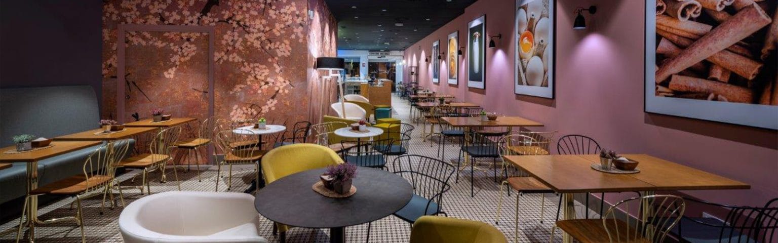 Stylish cafeterias with wood tables, metal chairs, and floral wallpaper. Durable furniture solutions.