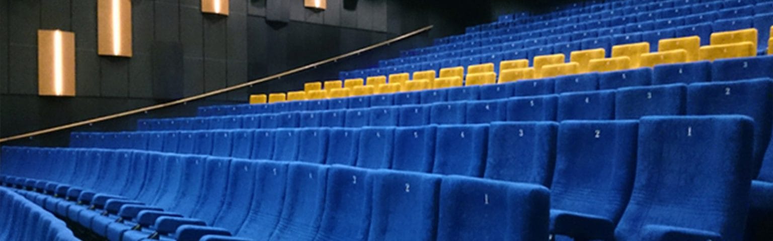 Rows of blue and yellow plush Cinema seating.