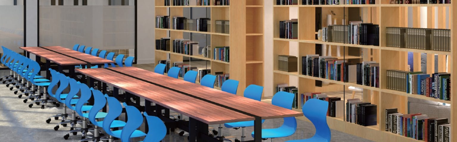 Library furniture with wooden tables, blue chairs, and filled bookshelves.
