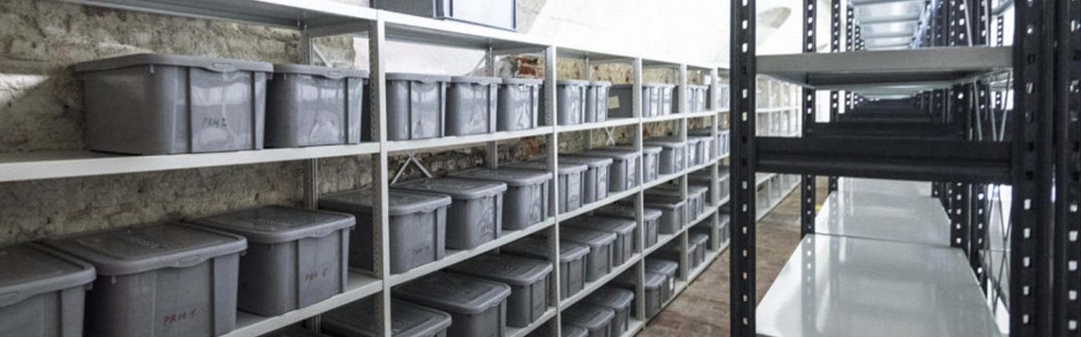 Gray bins on shelving. Warehouse Storage Solutions for efficient organization.