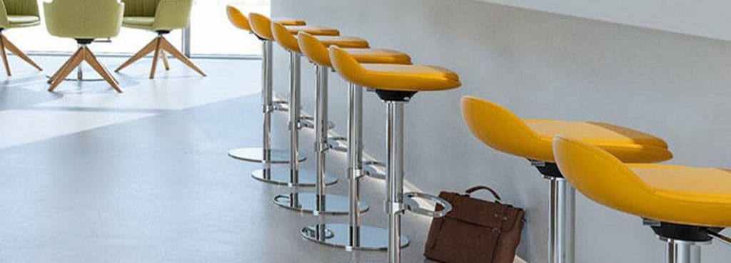 Row of yellow LIMEis5 stools with chrome bases, modern design for social spaces.