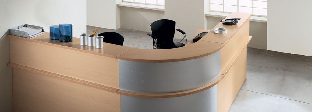 Kompas Reception desk in light wood and silver. Functional, spacious welcome area furniture.