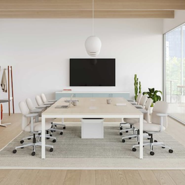 Bright conference room featuring a Layout Studio table with white frame and light wood top.
