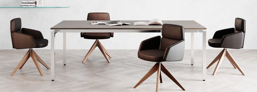 Modern Lead Visitor Chair in brown leather with wood base, around a table.
