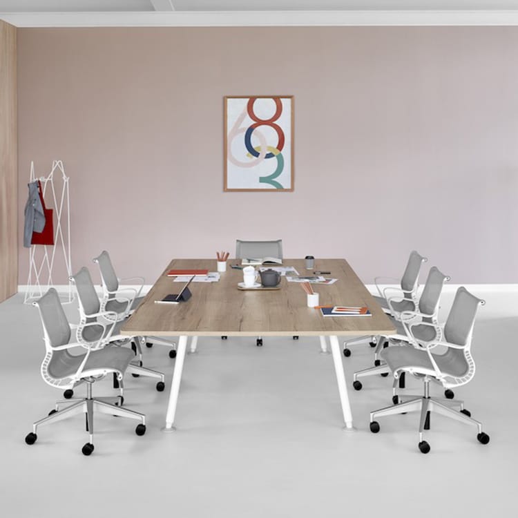 Modern conference room featuring a wood-grain Locale Conference Table and gray chairs.