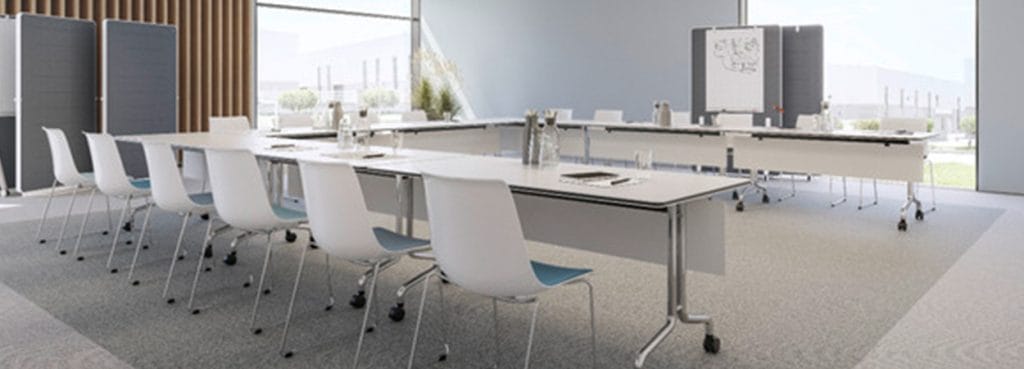Conference room featuring NESTYis3 tables and white chairs. Versatile setup for seminars and training.