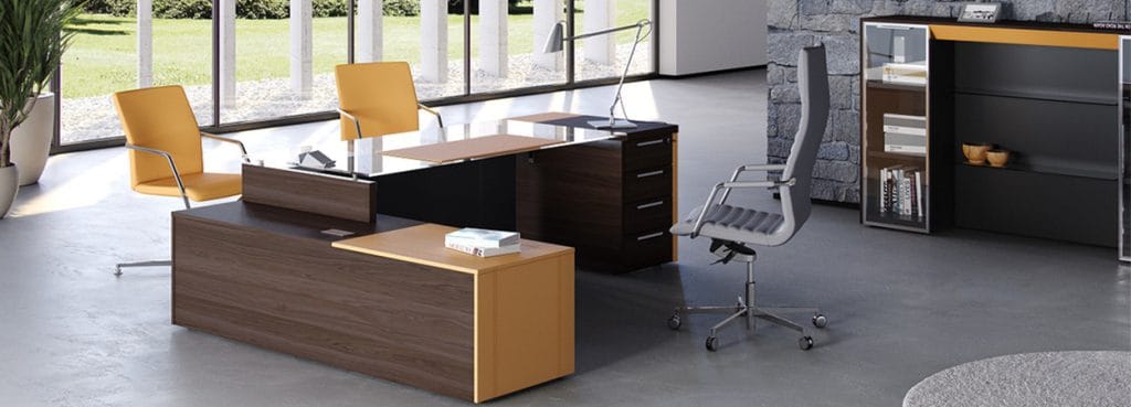 Executive office featuring the ONE collection: wood desks, yellow chairs, and a grey office chair.