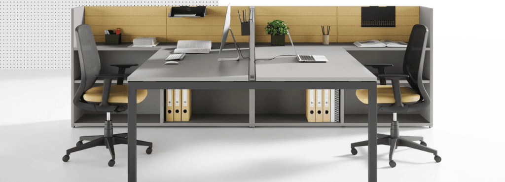 Modern OXI operative desk with gray top, black frame, and yellow accents. Office furniture for collaborative workspaces.