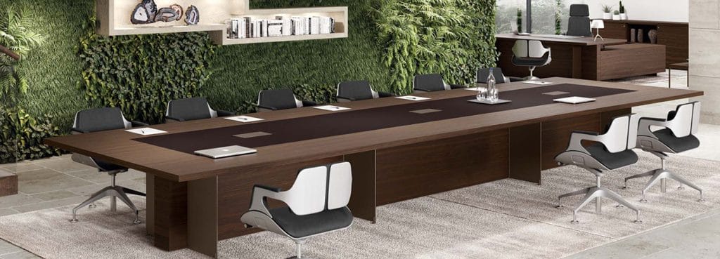 Oasi Executive Meeting Table: Sleek, wood-grain conference table with modern chairs, perfect for collaboration in executive spaces.