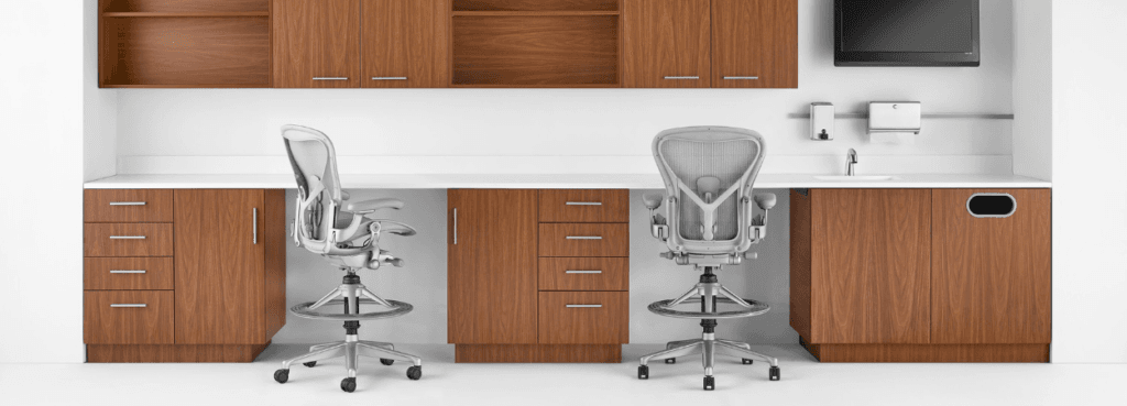 Modern office setup with two Aeron Stools, gray mesh, adjustable height, and rolling base.