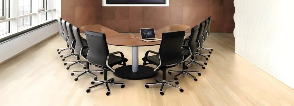 Conference room featuring black FS-Line chairs around a wooden table with a laptop.