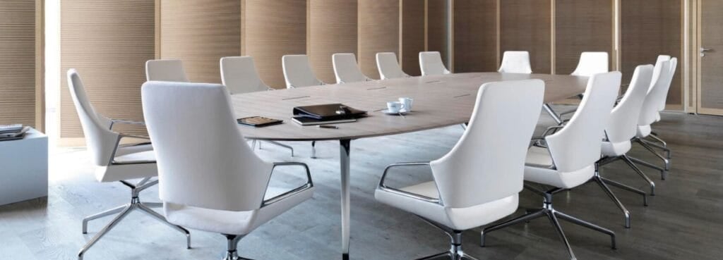 Conference room featuring white leather Graph chairs and an oval table.