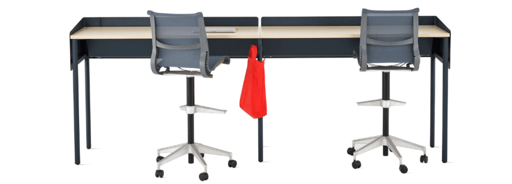 Two gray Setu Stools at a desk, showcasing ergonomic design for collaborative spaces.