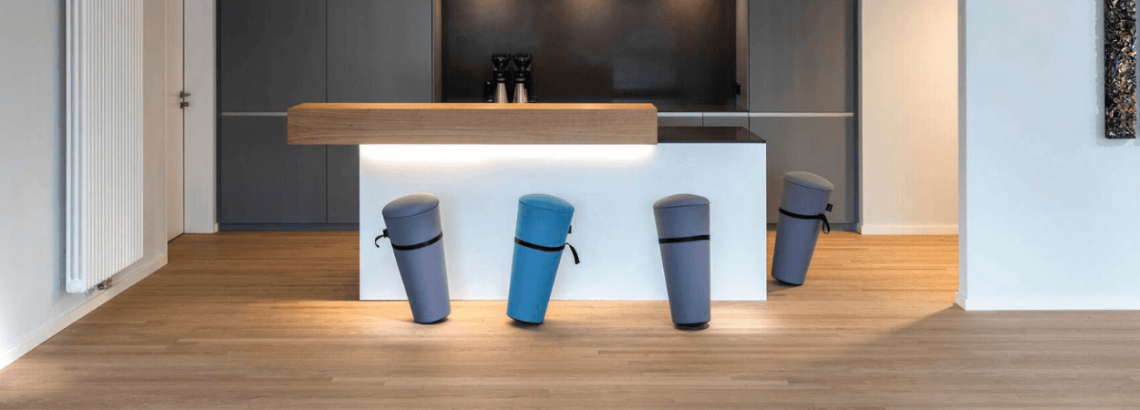 Wilkhahn Stand-Up stools in blue and gray, self-righting design for active seating in a modern space.
