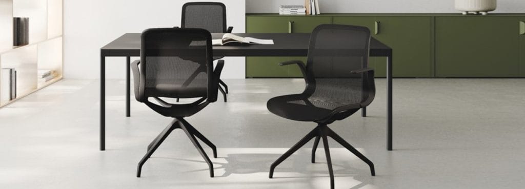 Modern black Trama visitor chairs with mesh back and seat.