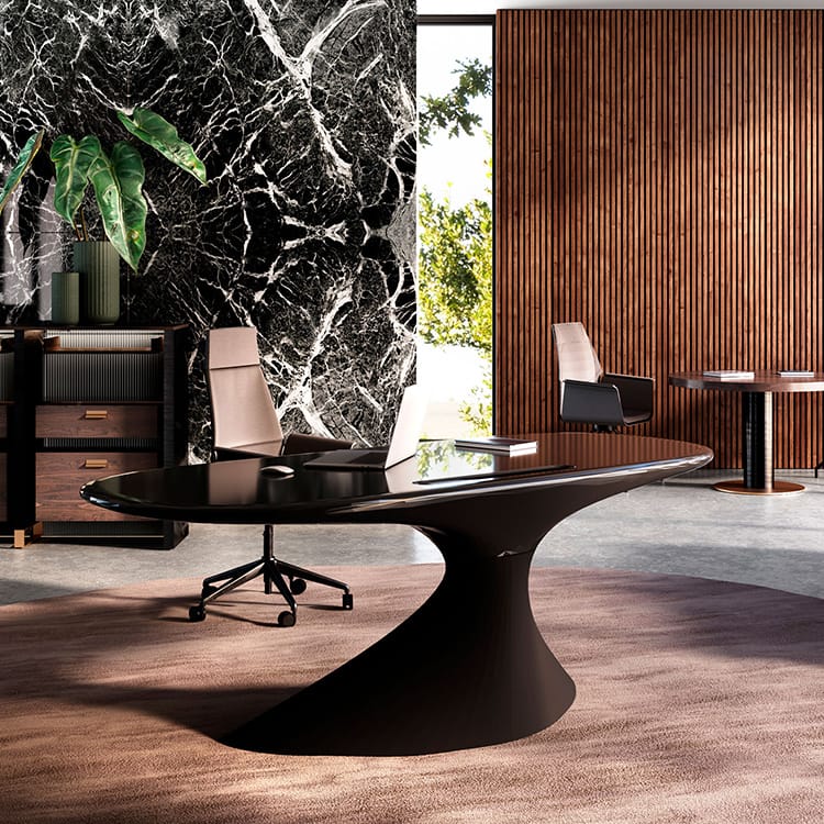 Sleek black ZERO executive desk with a unique, sculptural base in a modern office setting.