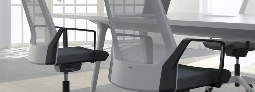Close-up of a light gray Interstuhl BUDDYis3 chair with a mesh back and black armrests.