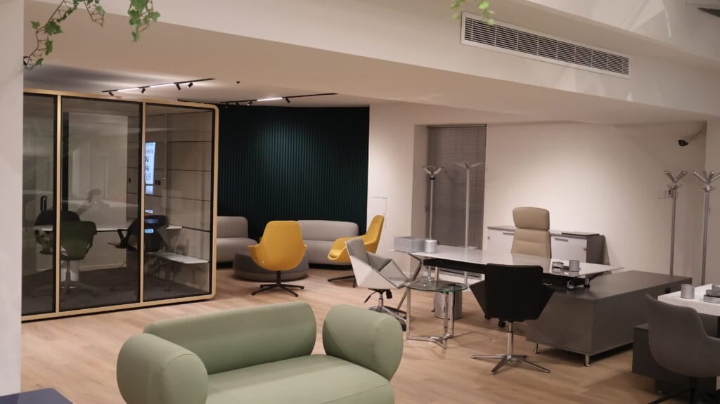 Studio office design in Nicosia. IMG_2754 shows a modern office interior with stylish furniture and a glass-enclosed meeting pod.