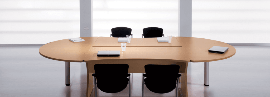 Modern KOMPAS Meeting Table in light wood with silver legs and black chairs.