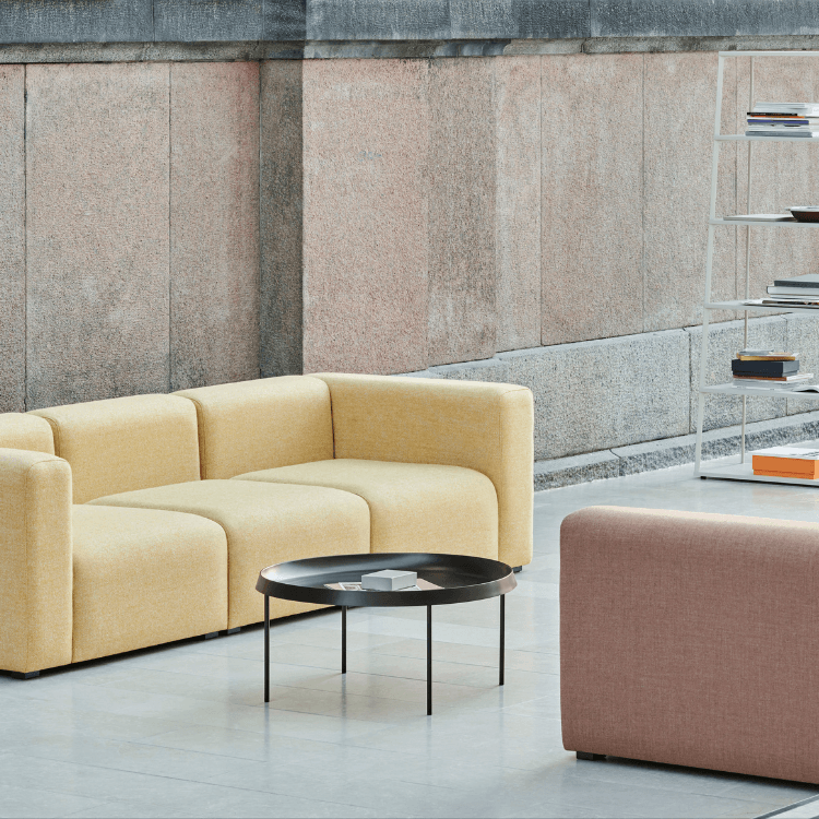 Modern Mags Sofa by HAY in yellow and pink with a black table, offering modular seating for stylish spaces.