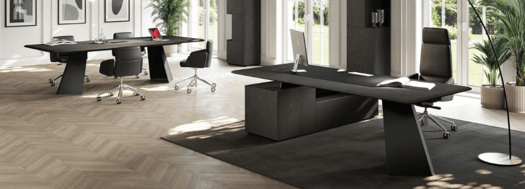 Modern office featuring the Monolith Executive Desk with a dark top and unique metal base.