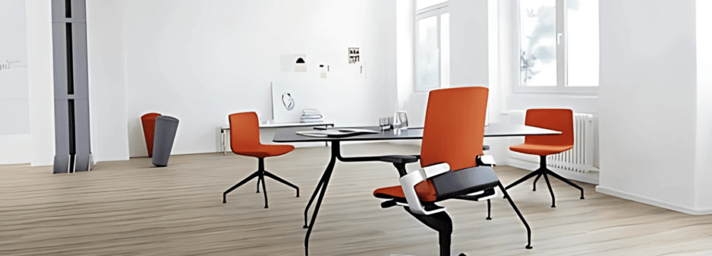 Modern office space featuring the Pep chair in orange, with a sleek aluminum base.