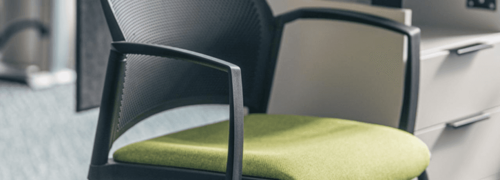 Close-up of a Replay seminar chair with green seat and black frame.
